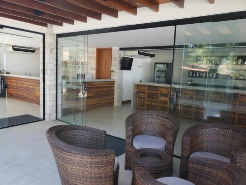 a living room with glass walls and wicker chairs at Deck de Búzios in Búzios