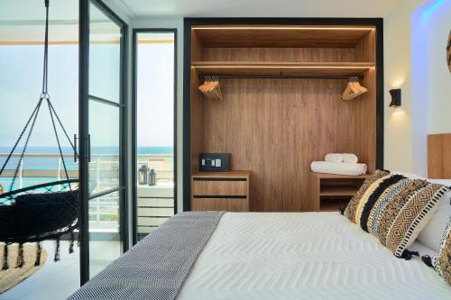 PURA VIDA Luxury apartment with jacuzzi في توريمولينوس: غرفة نوم مع سرير وإطلالة على المحيط