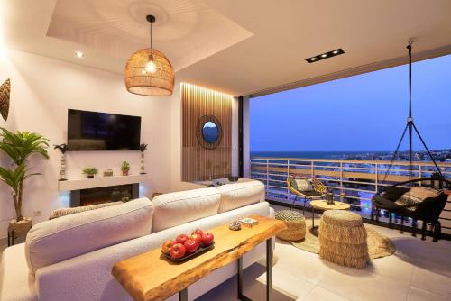 a living room with a white couch and a large window at PURA VIDA Luxury apartment with jacuzzi in Torremolinos