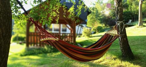 a hammock hanging from a tree in a yard at Wiślany Raj in Wisła