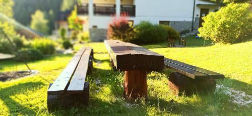 a wooden bench sitting in the grass in a field at Wiślany Raj in Wisła