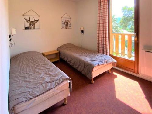 2 Betten in einem Zimmer mit Fenster in der Unterkunft Chalet La Joue du Loup, 3 pièces, 7 personnes - FR-1-504-592 in Le Dévoluy