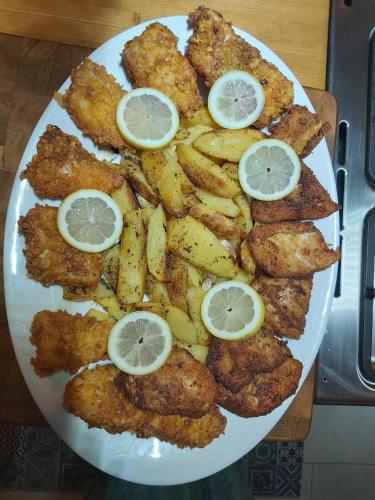 a plate of food with lemon slices on it at Agropensiunea Beluga in Gorgova