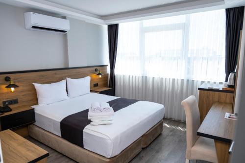 a hotel room with a bed with towels on it at Comfort Center Suit Hotel in Edirne