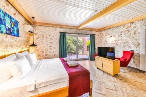a bedroom with a bed and a tv in a room at Atalante Hotel in Kas