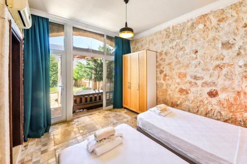 a bedroom with two beds and a large window at Atalante Hotel in Kas
