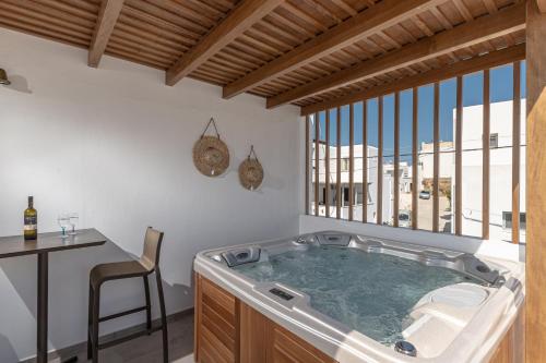 a hot tub in a room with a table and a chair at Naxos Apartment in Naxos Chora