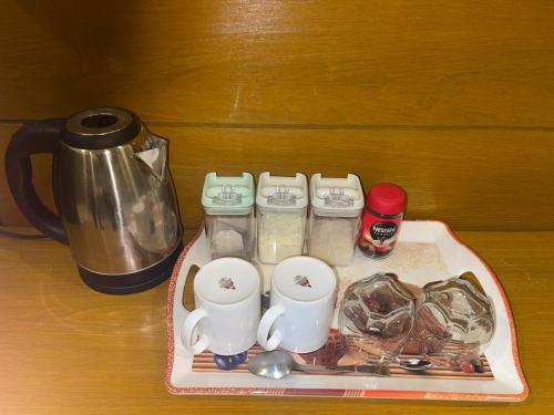 LiāquatpurにあるMughal E Azam Hotelのテーブルの上にカップと調理器具を並べたトレイ