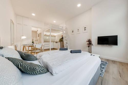 a white bedroom with two beds and a dining room at Studio Mala Strana - Prague historical center in Prague