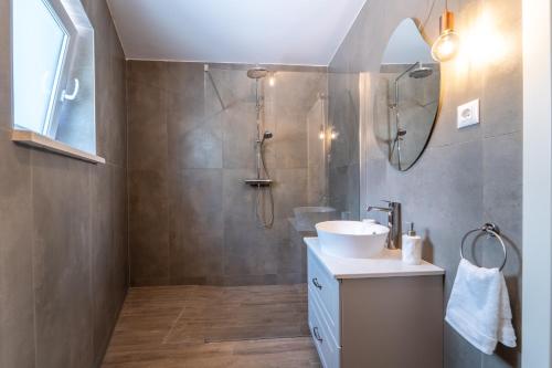 ein Bad mit einem Waschbecken und einer Dusche in der Unterkunft Villa Bruna in Sumartin