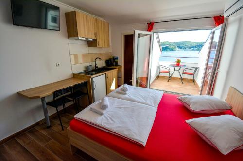 ein Schlafzimmer mit Bett und eine Küche mit Aussicht in der Unterkunft Apartmani Kordić in Rab