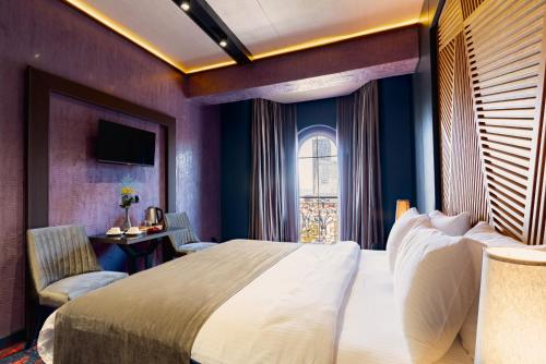 a bedroom with a large bed and a window at Tapis Rouge Design Boutique Hotel in Batumi