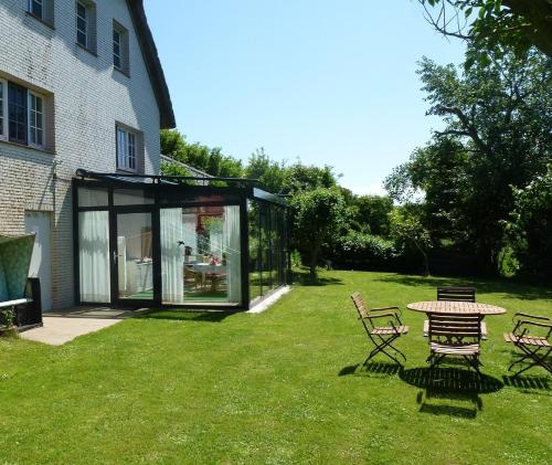 a glass house with a table and chairs in the yard at Austernfischer Haus in Pellworm