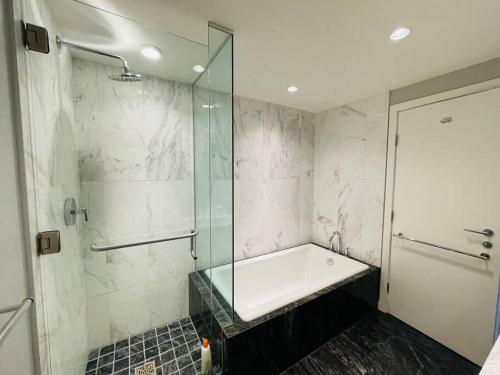 a bathroom with a glass shower and a tub at WaterFalls Hotel - Deluxe 2 bedroom suite downtown free parking with pool and Air Conditioning in Victoria