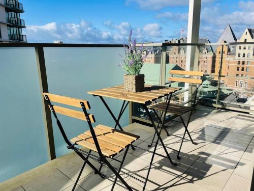 a table and two chairs on a balcony at WaterFalls Hotel - Deluxe 2 bedroom suite downtown free parking with pool and Air Conditioning in Victoria
