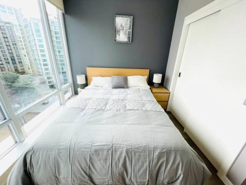 a large bed in a room with a large window at WaterFalls Hotel - Deluxe 2 bedroom suite downtown free parking with pool and Air Conditioning in Victoria