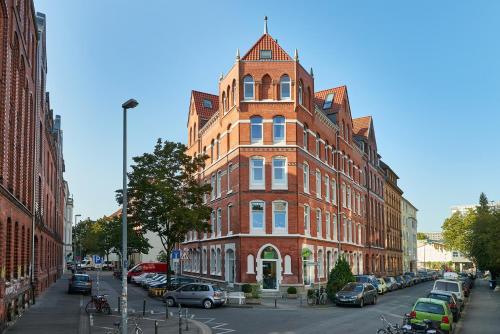 un alto edificio di mattoni rossi su una strada cittadina di Lofts in Hannover ad Hannover