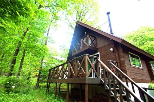 a cabin in the woods with a large deck at HARUNA LODGE - Vacation STAY 12175 in Nasu
