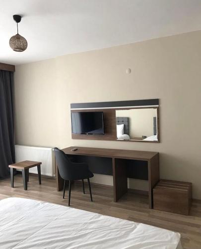 a bedroom with a desk with a mirror and a bed at Alya Teras Otel in Trabzon