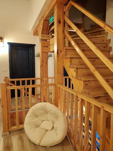 a wooden staircase with a white chair in a room at Agropensiunea Beluga in Gorgova
