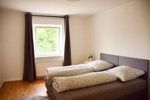 a bedroom with two beds in front of a window at Haus mit 3 Apartments im Zentrum von Rostock in Rostock