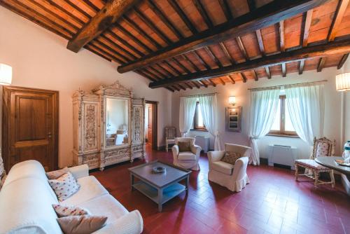 a living room with a white couch and chairs at Castello Vicchiomaggio in Greve in Chianti