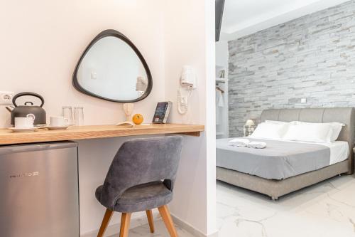 a bedroom with a bed and a mirror and a chair at Dimitra Hotel in Agios Prokopios