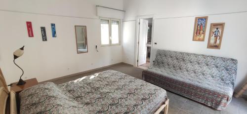a bedroom with a bed and a couch in it at Seaside Villa with Hot Tub, 5mins walk from the sea in Torre rinalda