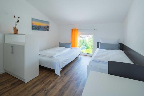 1 dormitorio con 2 camas y ventana en Boardinghouse Kastanienring en Reichertshausen