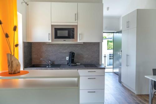 a kitchen with white cabinets and a sink at Boardinghouse Kastanienring in Reichertshausen