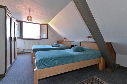 two beds in a room with a attic at S'Harzala Vert bis in Bergheim