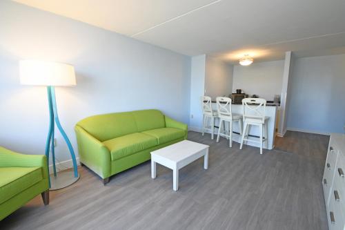 a living room with a green couch and a table at Fenwick Inn in Ocean City