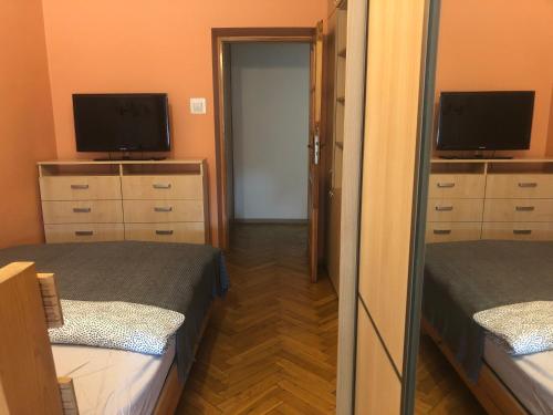 a small room with two beds and a television at Blue River - Plac Legionow in Wrocław