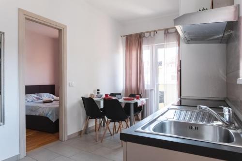 a kitchen with a sink and a table with chairs at Apartments Time For Sea in Koper