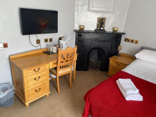 a bedroom with a bed and a desk with a television at The Angel Inn Stourport in Stourport