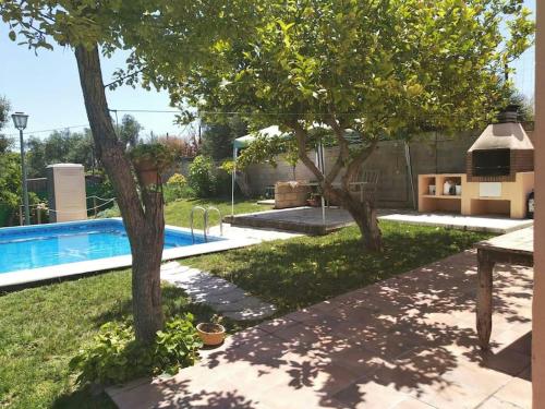 a backyard with a swimming pool and two trees at Vivienda Rural La choza in Jerez de la Frontera