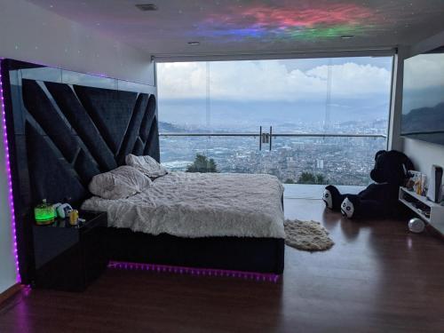 um quarto com uma cama em frente a uma grande janela em Nomad Finca em Envigado