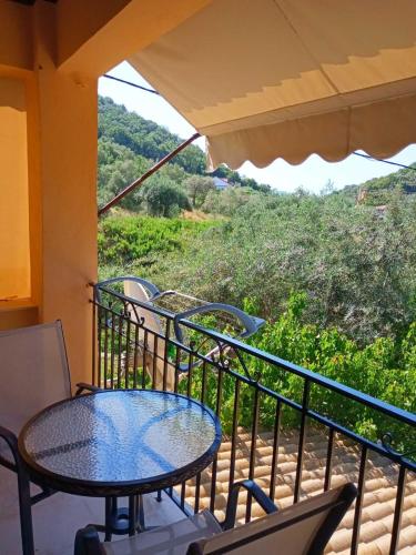 a table and chairs on a balcony with a view at Oliveto e mare in Sivota