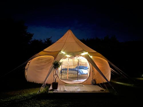 a tent with a window and lights in the dark at Secret Garden Glamping in Lymington