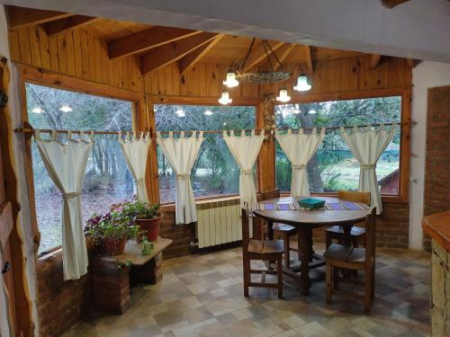 a dining room with a table and some windows at Maitenkarú in San Carlos de Bariloche