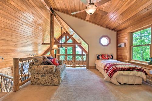 a bedroom with a bed and a couch in a room with wooden ceilings at Panoramic Mtn Views Luxe Smoky Mountain Cabin! in Waynesville