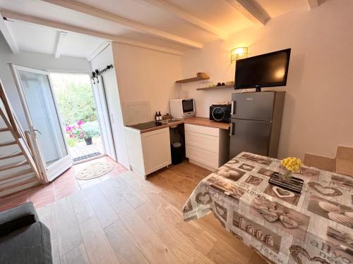 een kleine keuken met een koelkast en een aanrecht bij Appartement avec terrasse arborée proche LOURMARIN in Cadenet