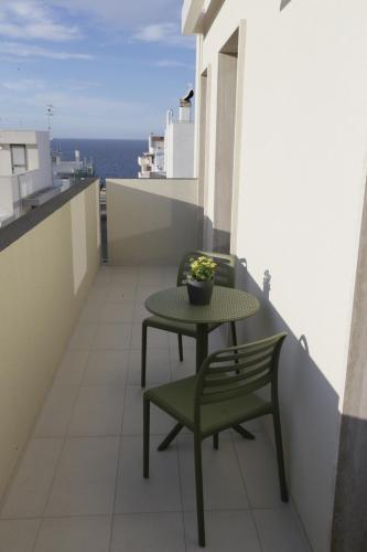 a table and a chair on a balcony with the ocean at SETTANNI Sea Suites in Polignano a Mare