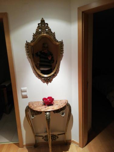 uma mesa lateral com um espelho na parede em Holaias Holidays em Lisboa