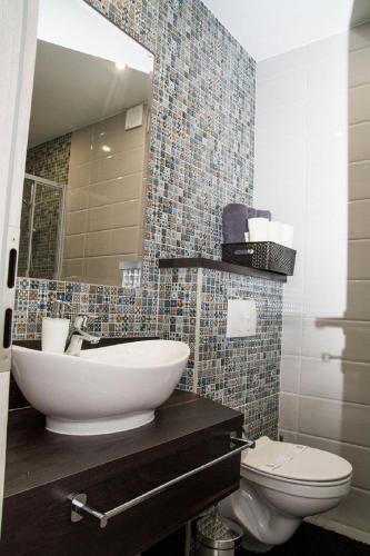 a bathroom with a sink and a toilet at Rooms The King's Pub in Kutina