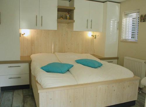 1 dormitorio con 1 cama con 2 almohadas azules en Apartment Silvamare, en Domburg