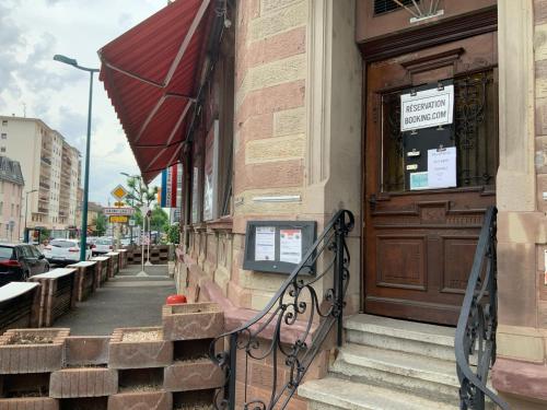 a building with a door and stairs on a street at Studio/Hôtel Porte De France in Saint-Louis