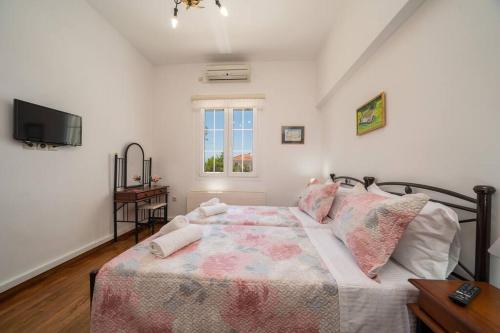 a bedroom with a bed and a television in it at Villa Erasmia- House 1 ground floor in Sarláta
