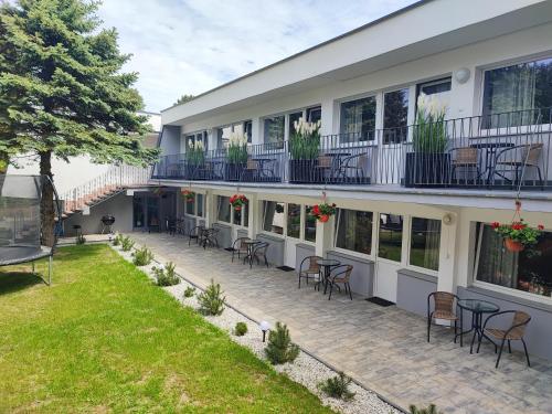 un patio al aire libre con sillas y mesas frente a un edificio en Bella Rossi en Jastrzębia Góra