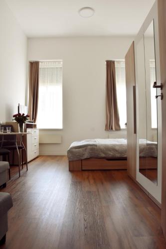 a bedroom with a bed and a desk and a mirror at A12 Home Sárvár in Sárvár